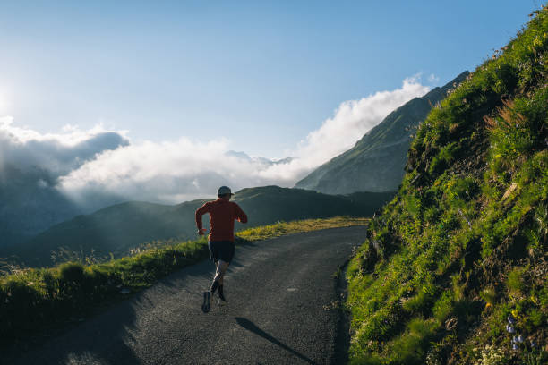 istock Trail runner bounds along mountain road 2165874524