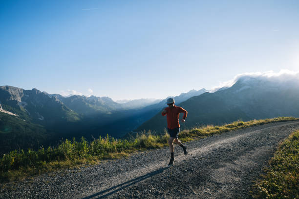 istock Trail runner bounds along mountain road 2165874526