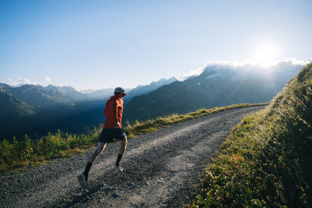 istock Trail runner bounds along mountain road 2165874527