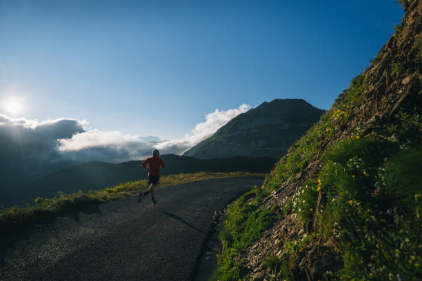 istock Trail runner bounds along mountain road 2165874686