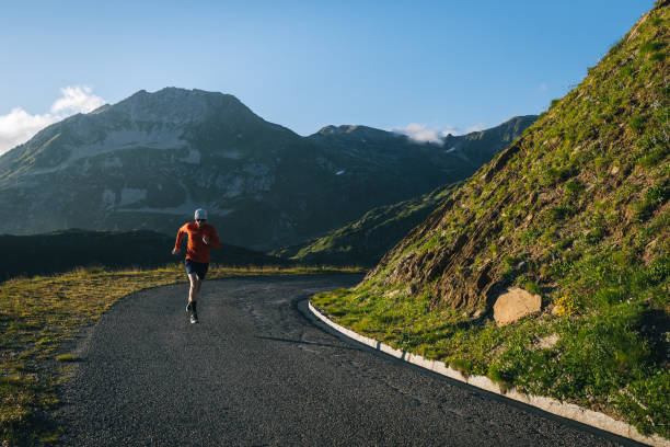istock Trail runner bounds along mountain road 2165874861