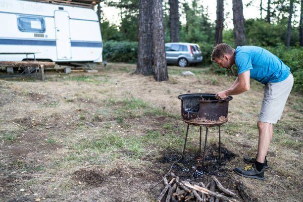 istock Young man preparing wood for campfire 2165876618