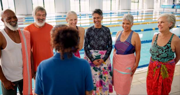 istock Swimming pool, senior people and discussion for learning, exercise and training together indoors. Water sports, hydro and physiotherapy for group aqua rehabilitation, health and wellness with coach 2165876688