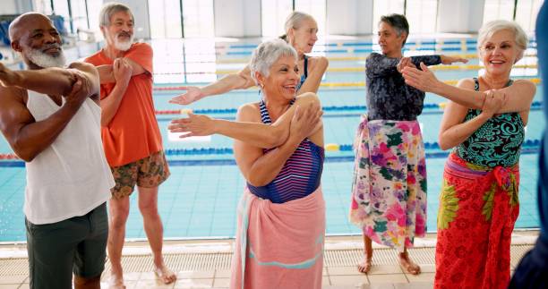istock Swimming pool, senior people and warm up for learning, exercise and training together indoors. Water sports, hydro and physiotherapy for group aqua rehabilitation, health and wellness with coach 2165876692