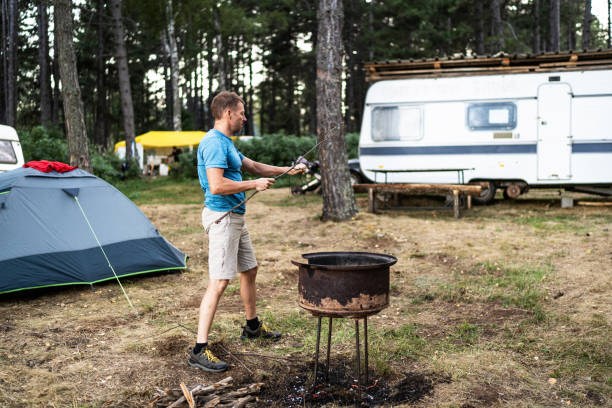 istock Young man preparing wood for campfire 2165876700