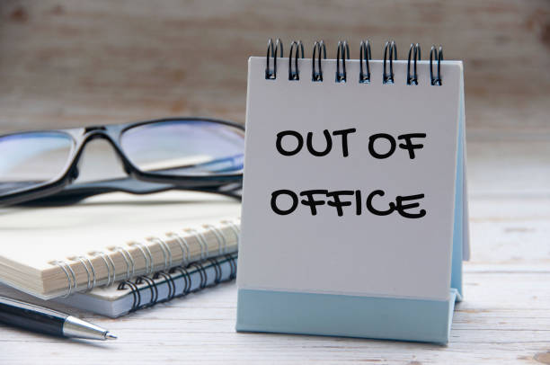 istock Out of office text on white notepad with notes and glasses background 2165877415