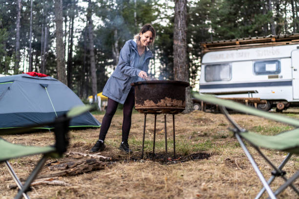 istock A young woman makes a fire in nature while camping 2165878831