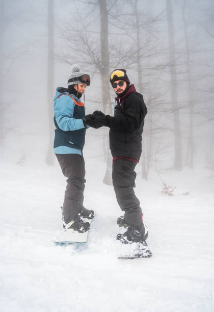 istock Man teaching his girlfriend to snowboard 2165878913