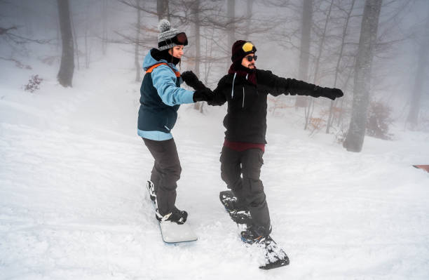 istock Man teaching his girlfriend to snowboard 2165878942