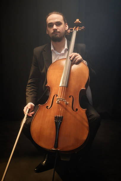istock Professional Musician Posing with Cello on Black Background 2165879028