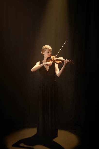 istock Graceful Violinist Playing Classical Music in Spotlight 2165879030