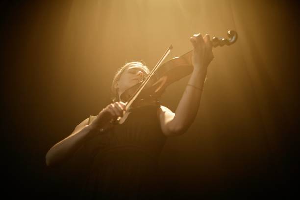 istock Passionate Violinist Performing Solo Concerto under Projector Light 2165879034