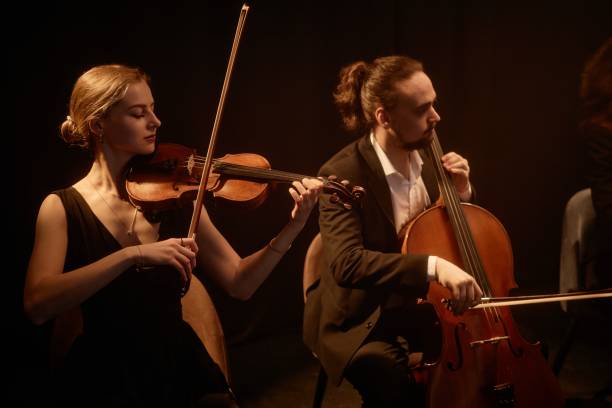 istock Violinist and Cellist Playing Music on Stage 2165879075
