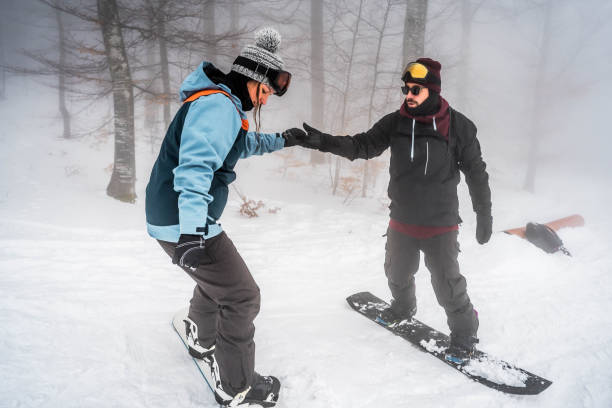 istock Man teaching his girlfriend to snowboard 2165879928