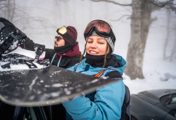 istock Snowboarders pack equipment into car 2165883599