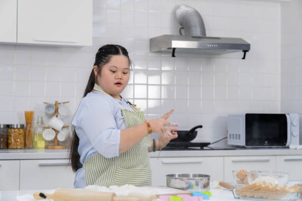 istock A young girl happily practicing cooking in the kitchen. 2165884557