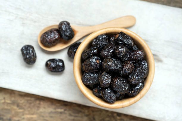 istock dried fruit in wooden bowl and spoon on marble background. 2165889252
