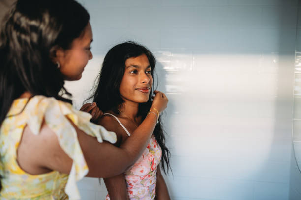 istock Young woman fixing her sister's hair before going out 2165889707