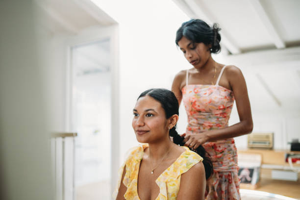 istock Young woman styling sister's hair before going out 2165889732