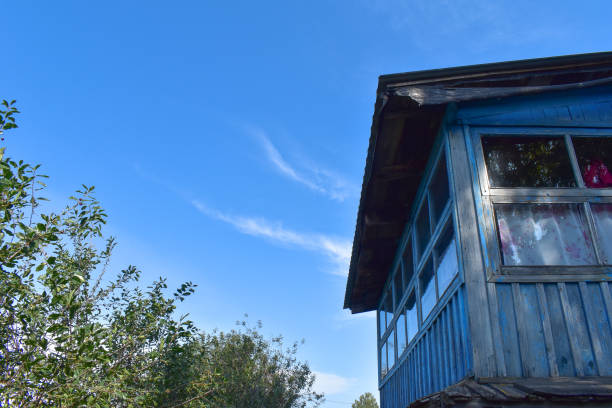 An image of an old wooden blue house with blue sky background