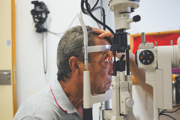 istock Elderly man undergoing slit lamp eye examination in an optometrist's office. Routine postoperative vision screening. 2165893191