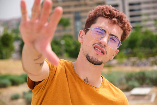 istock Young man making stop gesture with hand wearing sunglasses 2165893568
