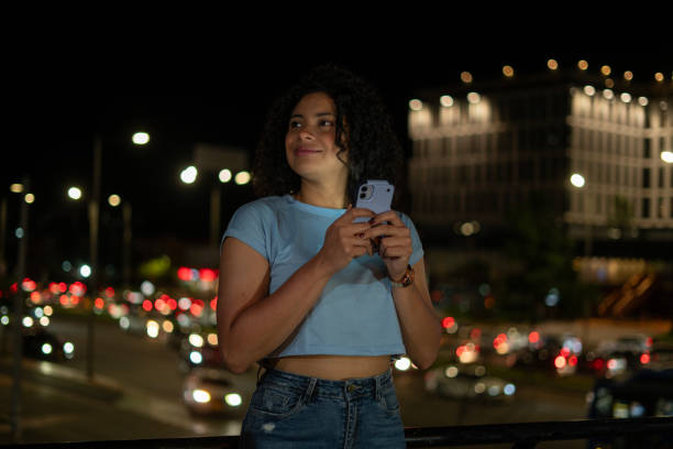 istock young woman with her cell phone at night 2165893792