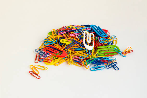 Above view of Colorful paperclips heap on the white surface with copy space.Conceptual image of education.