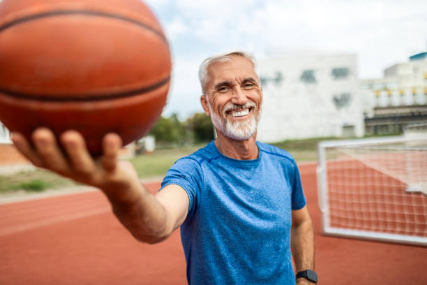 istock Mature Man Holding a Ball and Smiling 2165900723