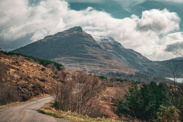 istock Scenic Scottish Highlands disappearing into misty mountains, with dense foliage on either side 2165900947