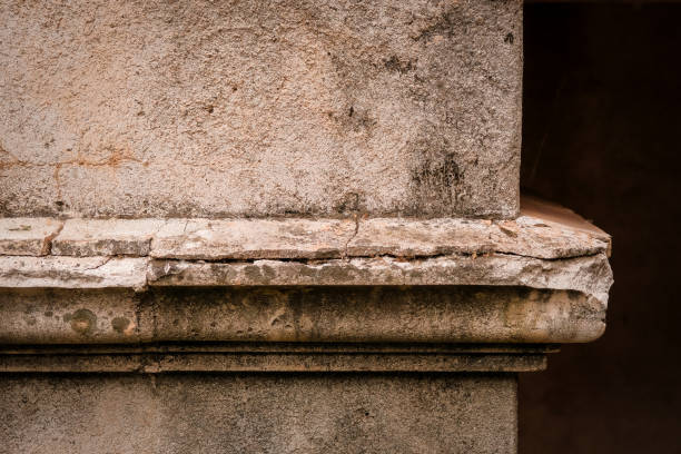Well worn concrete ledge at corner with cracks and stains
