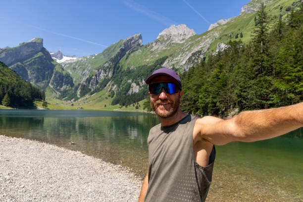 istock Man Taking Selfie by Mountain Lake on Sunny Day 2165901293