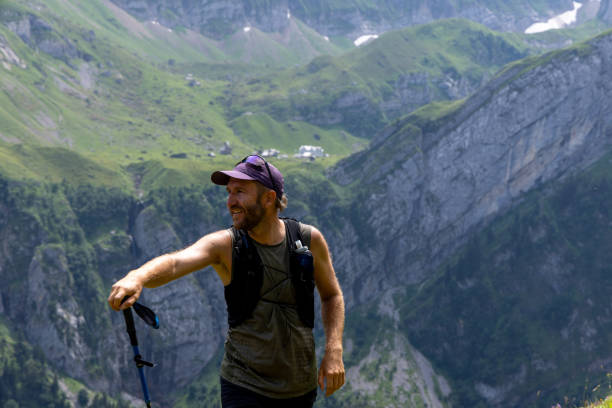 istock Smiling Man Hiking with Trekking Pole in Mountains 2165901485