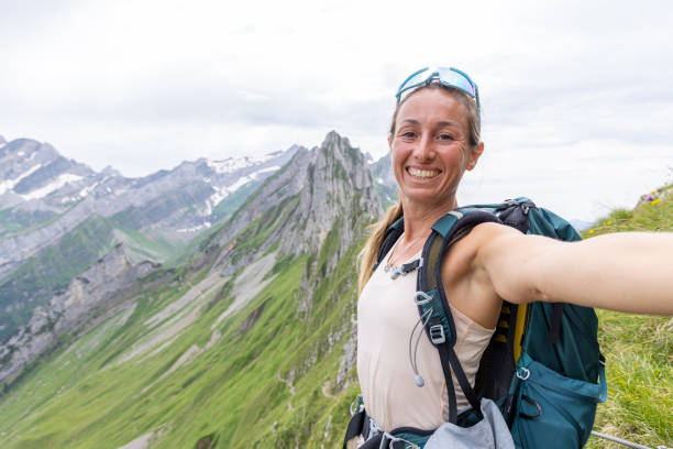 istock Woman Taking Selfie on Mountain Hike with Backpack 2165901571