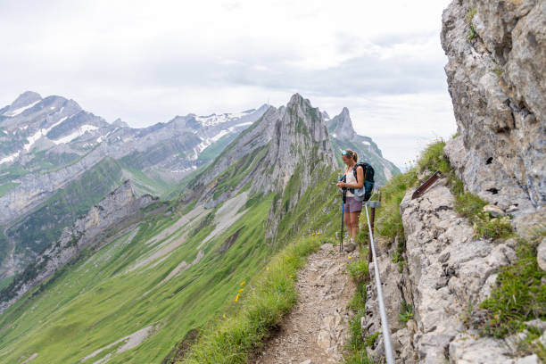 istock Woman Checking Phone on Mountain Hike with Backpack 2165901616
