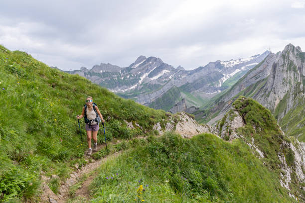 istock Woman Hiking on Mountain Trail Surrounded by Lush Greenery 2165902365