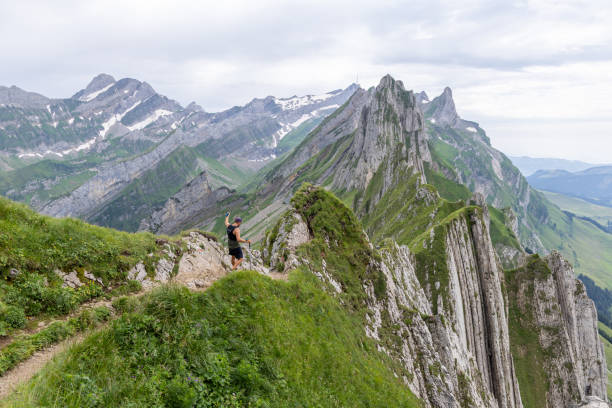 istock Man Hiking on Narrow Mountain Ridge with Stunning Views 2165902368