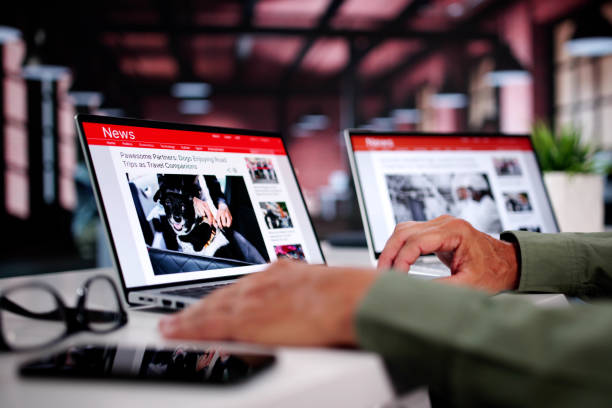 istock Watching Online News Article On Mobile Phone And Laptop 2165903971