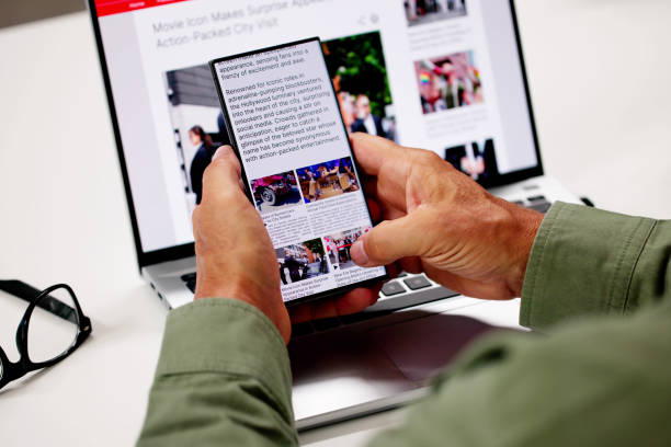 istock Watching Online News Article On Mobile Phone And Laptop 2165903996