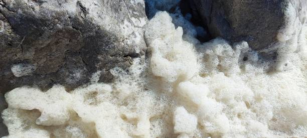 Frothy, foamy sea waves going up steps, at Porthcawl South Wales UK.