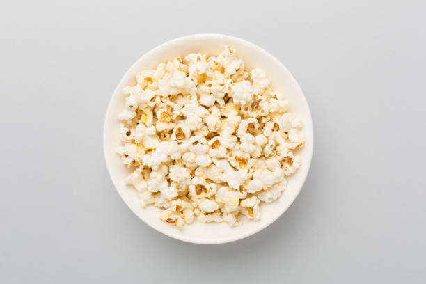 istock Tasty popcorn in bowl on color background, top view 2165911383