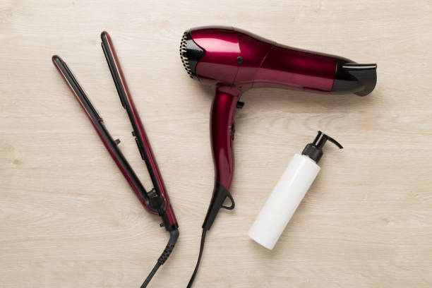istock Hair tools with thermo protection on wooden background, top, view 2165911384