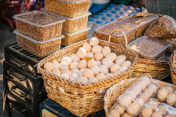 Fresh eggs and nuts displayed in wicker baskets at a bustling market in the morning