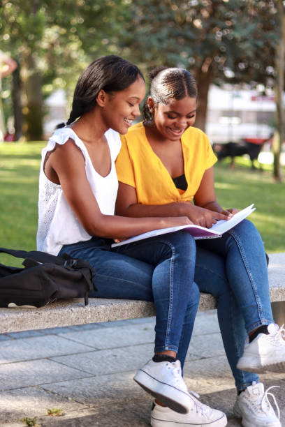 istock Two hispanic women students studying together on a campus bench 2165923271