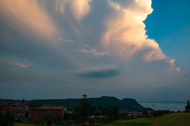 Immense storm cloud over Lake Garda, Italy is beautifully illuminated by the low sun.