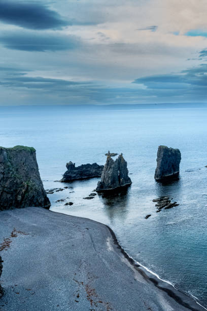 istock Pointed rocks sticking out from the ocean with a rocky beach 2165927974