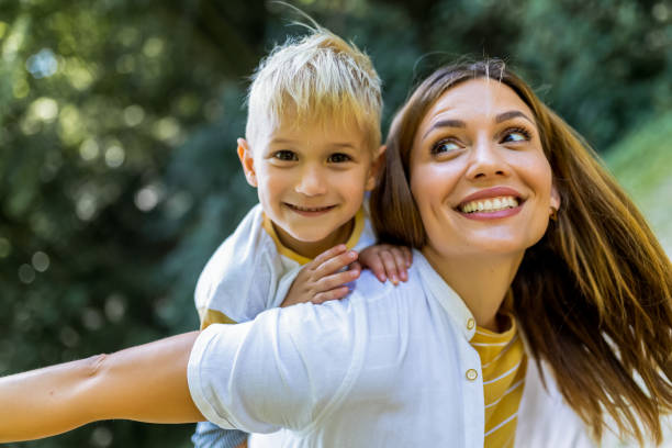 istock Young beautiful mother playing with her son piggy back. 2165929272