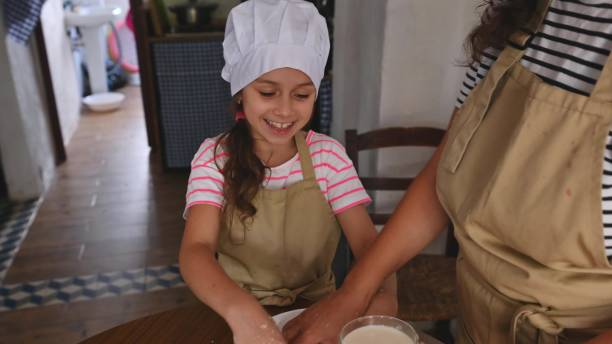 istock Mother and daughter baking together in cozy home kitchen 2165934877