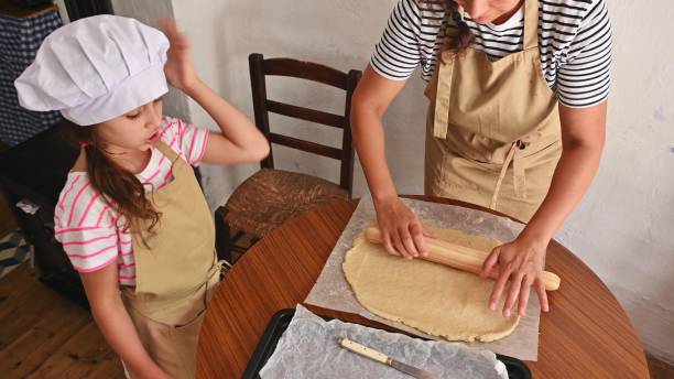 istock Mother and daughter baking together at home, making dough 2165934912