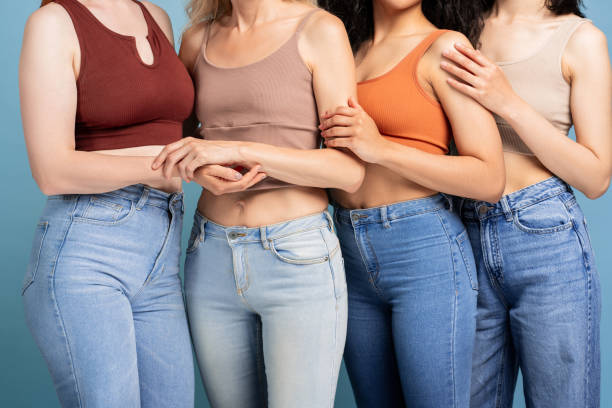 istock Diverse group of women holding hands showing support, closeup, posing isolated on blue background 2165935507